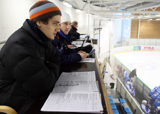 Sports team scouts watching players play hockey