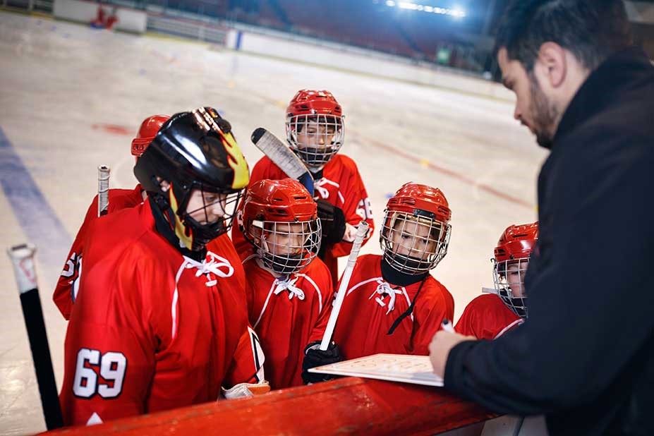 A hockey sports evaluator conversing with players